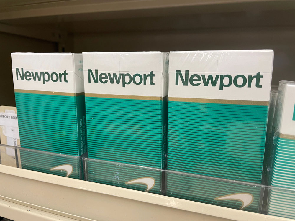 cigarette shop tulsa shelf with multiple newport menthol cigarette packs in plastic holder and visible product branding label