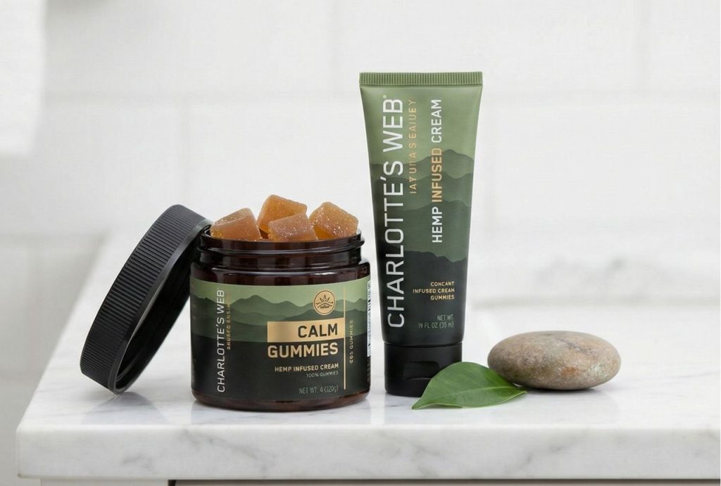 An open jar of Charlotte's Web Calm Gummies and a tube of hemp-infused cream on a marble counter, representing the diverse offerings you can find at a CBD shop in Tulsa.