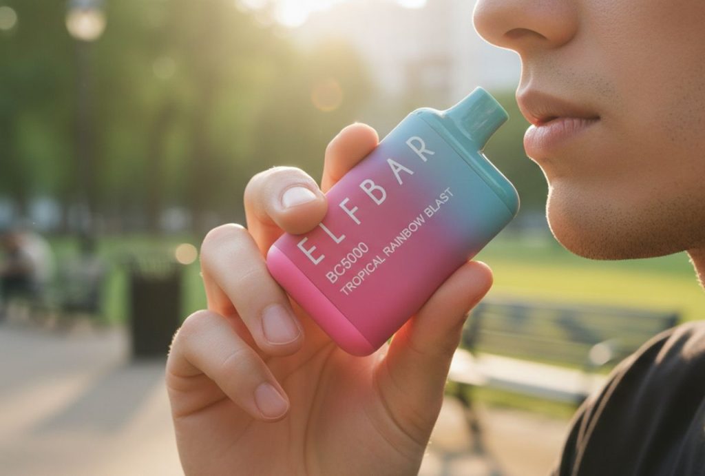 A person enjoys a Tropical Rainbow Blast Elf Bar BC5000 outdoors, a popular choice for disposable vapes Tulsa residents seek.