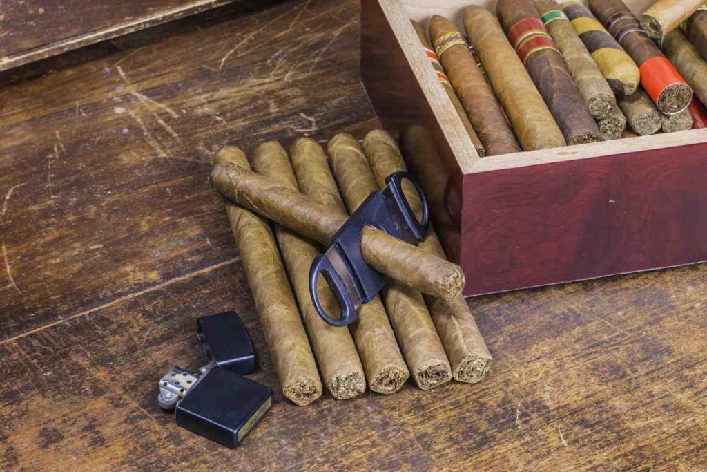 Premium cigars with a cutter, lighter, and wooden humidor box at a popular cigar shop Tulsa. 