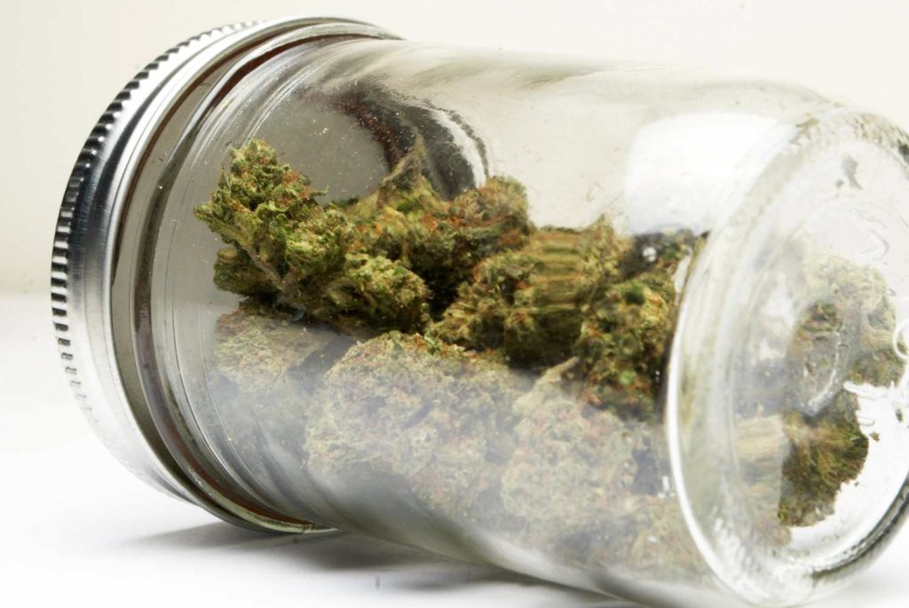 A glass mason jar filled with high quality hemp flowers on display at a top rated delta 8 store tulsa dispensary.