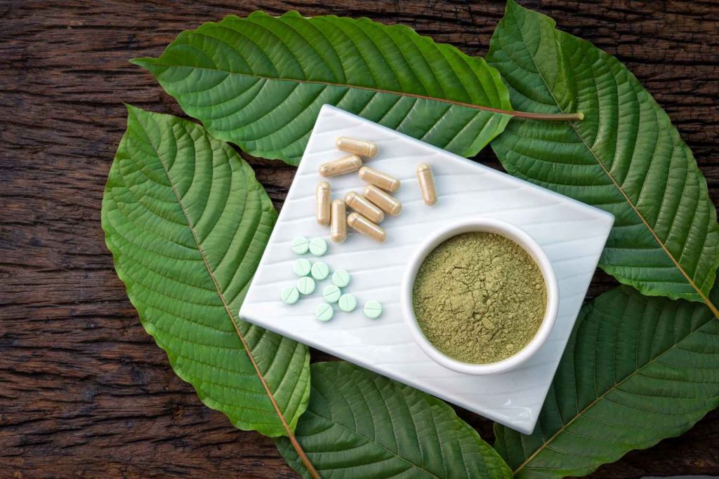 Pure kratom powder, tablets, and capsules on a white plate, ideal for quality kratom retail Tulsa blog product reviews. 