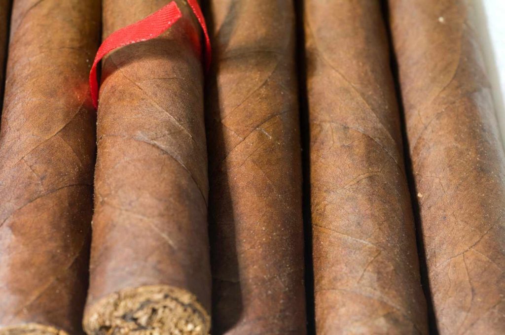 Premium hand-rolled cigars with a red ribbon wrapper at a cigar shop Tulsa location. 