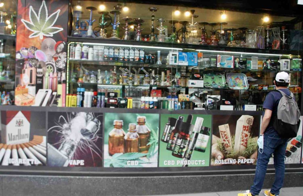 Customer browsing vapes and CBD products at a well-stocked smoke shop Tulsa storefront.