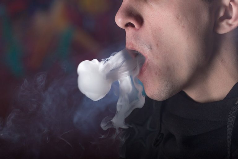 A close-up image of smoke coming out from a man on a Tobacco Shop near Tulsa.