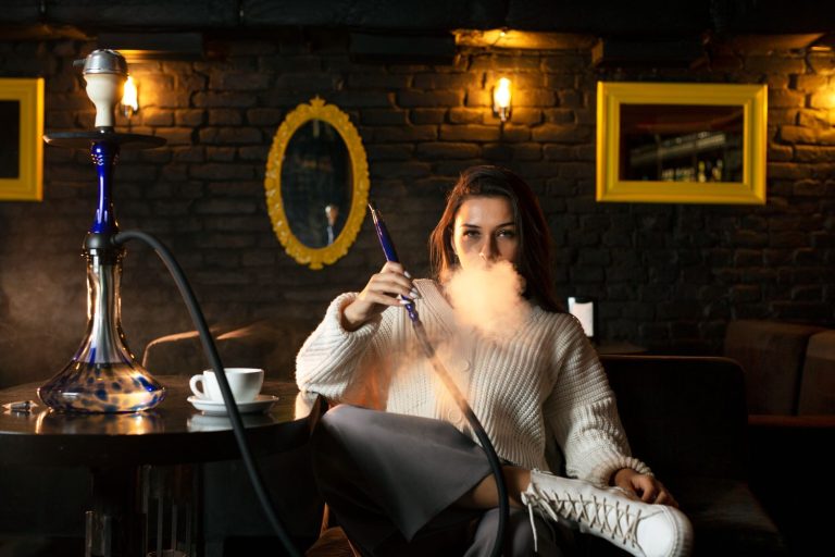 An image of a beautiful woman vaping alone in a hookah shop in Tulsa.