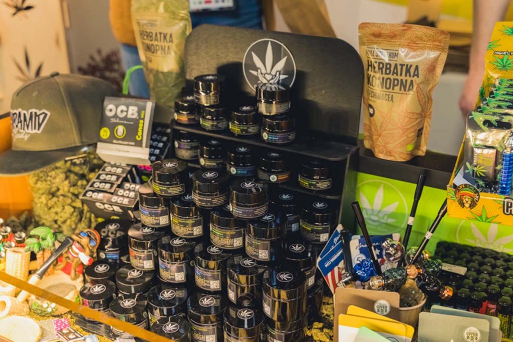 cbd store tulsa display with hemp tea, rolling papers, cannabis jars, and accessories at a branded retail booth